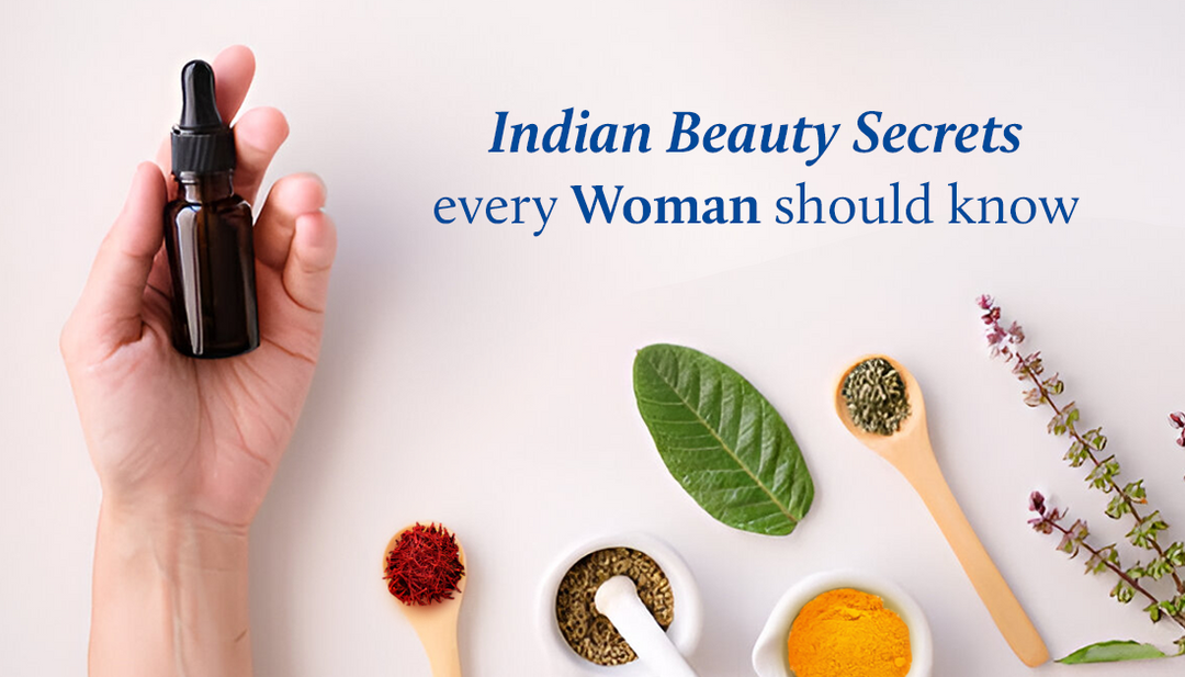 A woman is holding the face serum with various natural ingredients displayed on the table in front of her.