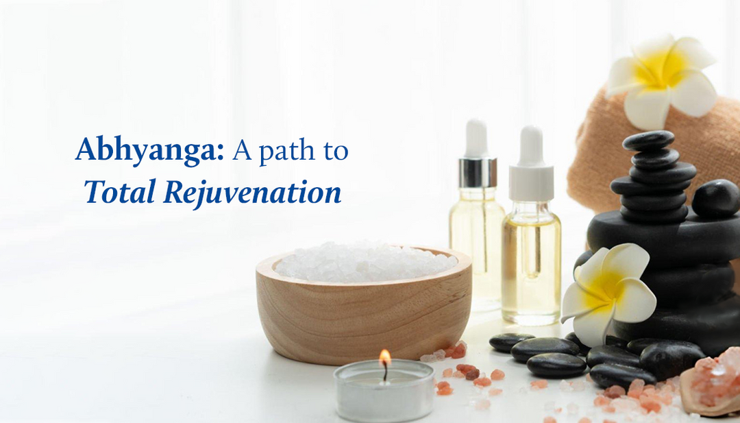Body oils, a candle, flowers, and a towel elegantly arranged on a white table.