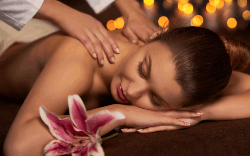 A masseuses' is giving massage by her hands on the back of the lady 